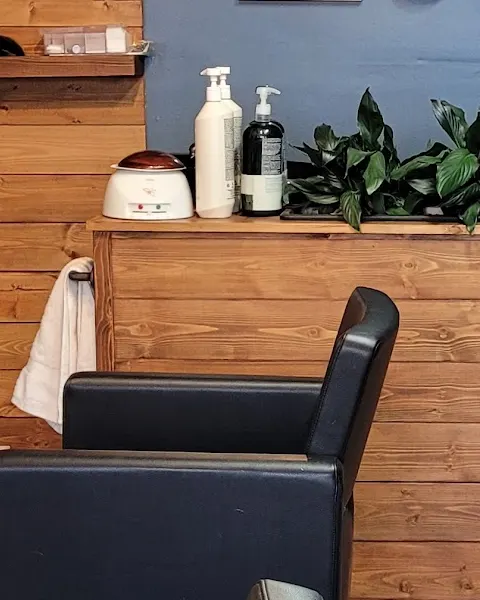 The wax warmer on the salon's pine counter, lid on, peace lilies behind
