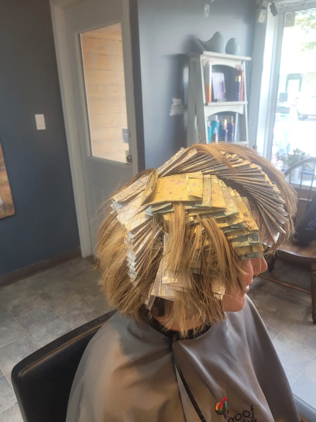 A client's hair folded into a full head of highlight foils, mid-appointment at the salon