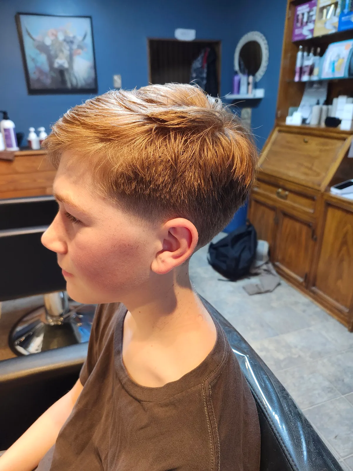 A teenager's fresh taper cut in the salon chair, tidy on top and faded clean at the sides